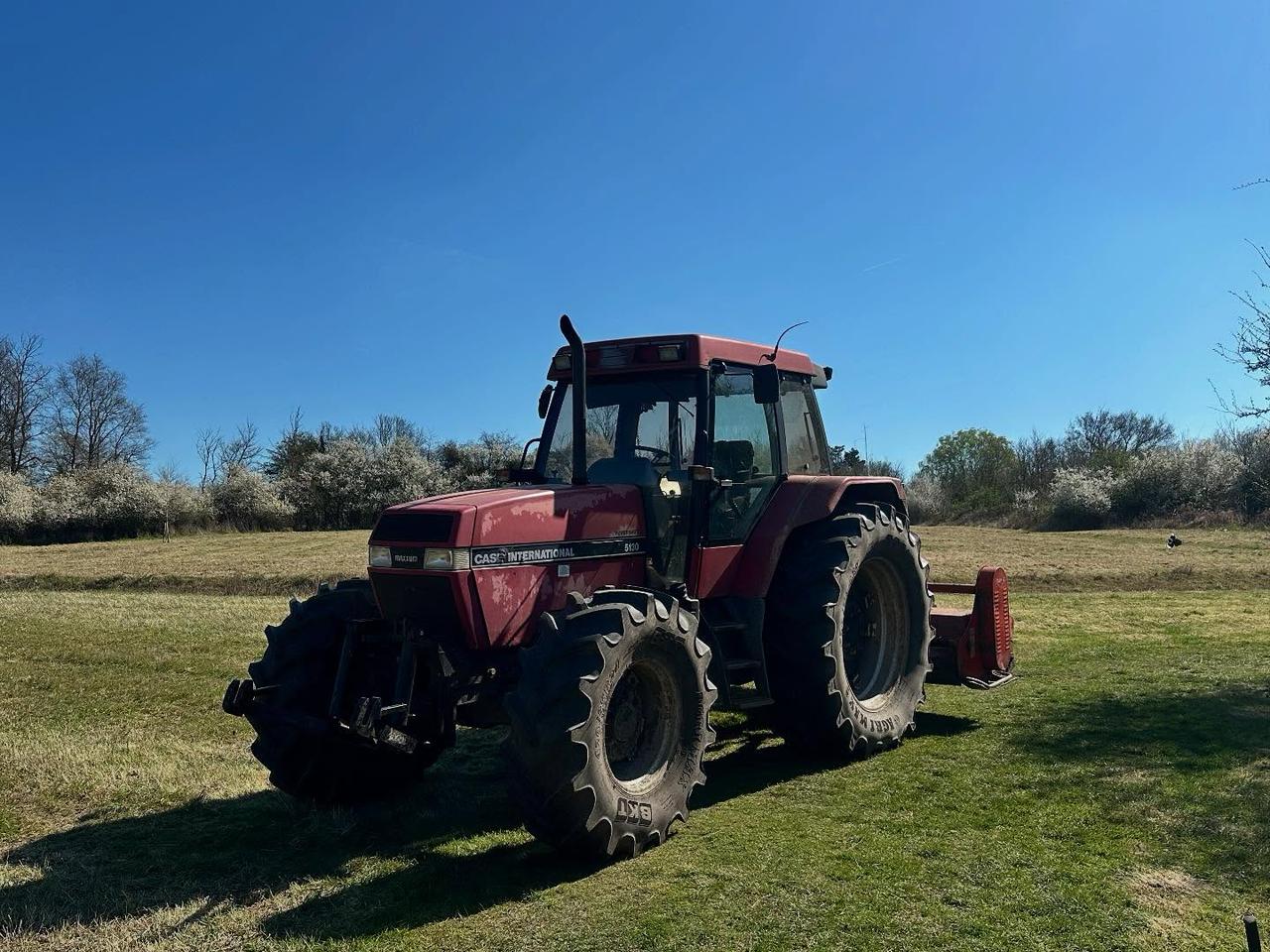 Tractor carrying out flail mowing on open ground